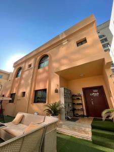a building with a door and chairs in front of it at The Villa Hostel - By Lunar in Abu Dhabi