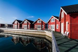 una fila de casas rojas junto a un cuerpo de agua en XLyngen, en Nord-Lenangen