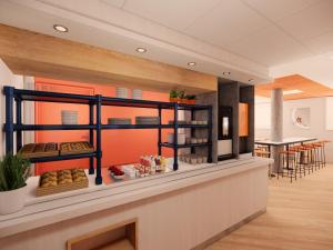 a bakery with a counter with food on it at ibis budget Valence Nord Plateau des Couleures in Saint-Marcel-lès-Valence