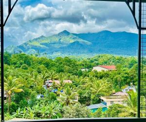 a view of a mountain from a window at Zonooro Homestay Vythiri in Vythiri