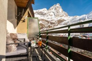 een balkon met uitzicht op een met sneeuw bedekte berg bij HelloCHALET TrackSide House - Ski-In Ski-Out Apartment on the Cretaz Slopes in Breuil-Cervinia