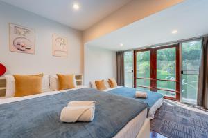 una camera da letto con due letti e una grande finestra di Bangkok Cozy Garden Pool Villa Sukhumvit a Amphoe Phra Khanong Altre 52 foto