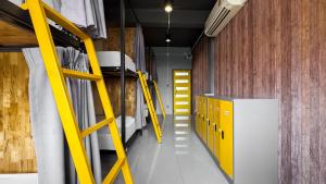 a room with bunk beds and a yellow ladder at Room 22 Hostel - near Chinatown in Bangkok +23 photos