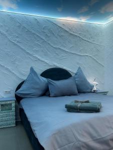 a white bed with blue pillows in a room at Cloud Express in Petroşani