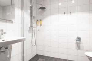 ein weißes Badezimmer mit Dusche und Waschbecken in der Unterkunft Good Morning Sollentuna in Sollentuna + 47 Fotos