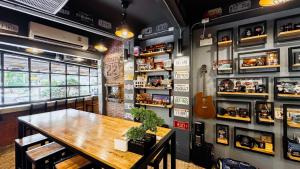 a room with a table and a guitar on the wall at Room 22 Hostel - near Chinatown in Bangkok