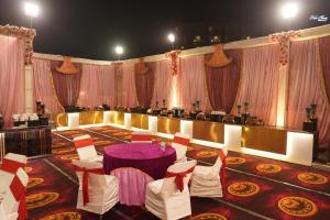 een feestzaal met een paarse tafel en stoelen bij Hotel Krishna Anandam in Vrindāvan