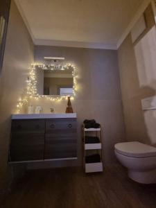 ein Badezimmer mit Waschbecken und beleuchtetem Spiegel in der Unterkunft M&M apartments in Monclassico