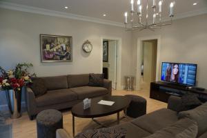 a living room with a couch and a tv at Wooden Villa APARTMENTS in Jūrmala
