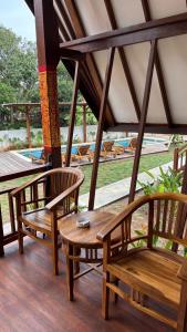 a porch with two wooden chairs and a table at Castaway Island Hostel in Nusa Lembongan