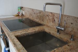 a kitchen counter with a sink and a faucet at Wooden Villa APARTMENTS in Jūrmala +42 photos