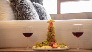 due bicchieri di vino rosso accanto a un piatto di frutta di Kaf Mount Erciyes a Hacılar