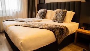 una camera da letto con un letto con un piumone e cuscini di Kaf Mount Erciyes a Hacılar