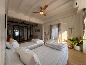 een slaapkamer met twee bedden en een plafondventilator bij Cloud House in Chiang Mai