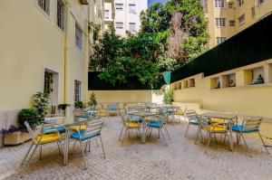 een groep tafels en stoelen op een binnenplaats bij Hotel Avenida Park in Lissabon