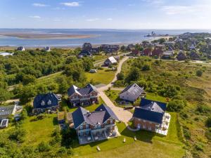 een luchtzicht op een huis met de oceaan op de achtergrond bij Haus Dünenperle, Ferienwohnung Wanderdüne in Wittdün