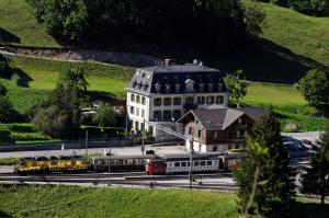 a large building with a train in front of it at Maison d'hôtes de la Gare in Montbovon
