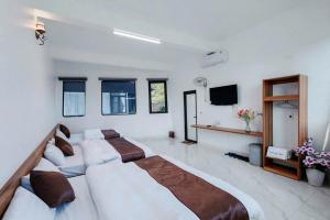 een grote slaapkamer met 2 bedden en een televisie bij Titanic Mộc Châu in Mộc Châu