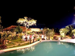 een groep mensen die 's nachts rond een zwembad zitten bij Titanic Mộc Châu in Mộc Châu