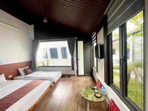 een slaapkamer met twee bedden en een groot raam bij Titanic Mộc Châu in Mộc Châu +37 foto's