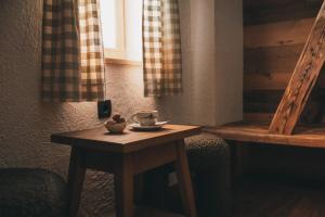 a small wooden table with a cup of coffee on it at Domačija Majer'ca in Bohinj