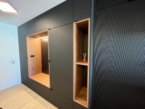 een inloopkast met zwarte muren en houten planken bij Mountain Loft - DuLac 33 in St. Moritz