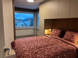 een slaapkamer met een groot bed en een groot raam bij Mountain Loft - DuLac 33 in St. Moritz +36 foto's