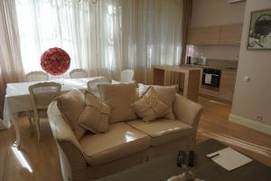 a living room with a couch and a table at Wooden Villa APARTMENTS in Jūrmala