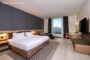 a hotel room with a large bed and a television at One Pacific Hotel and Serviced Apartments in George Town +71 photos
