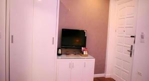 ein Zimmer mit einem Fernseher auf einem weißen Schrank in der Unterkunft Hanoi Milan Hotel in Hanoi
