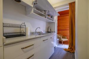 een keuken met witte kasten en een spoelbak bij Istanbul Hotelsophia in Istanbul
