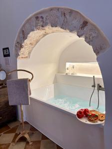 una bañera con un plato de comida. en La Suite di Alizeh, en Ostuni