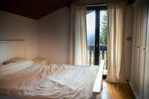 een slaapkamer met een bed en een groot raam bij Kopitnik cosy cabin in Dol pri Hrastniku