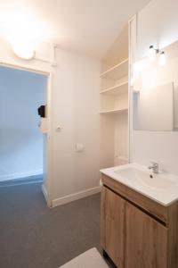 ein Badezimmer mit Waschbecken und Spiegel in der Unterkunft Kokoro - Parking in Ramonville-Saint-Agne