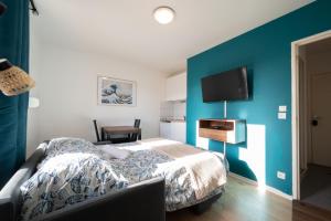 ein Schlafzimmer mit einem Bett und einer blauen Wand in der Unterkunft Kokoro - Parking in Ramonville-Saint-Agne