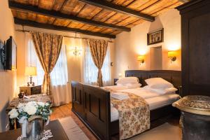 a bedroom with two beds and a table with flowers at Casa Savri in Sighişoara