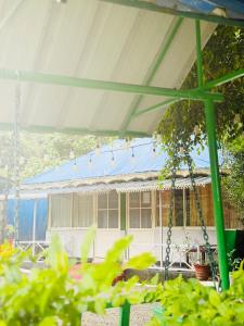 une balançoire devant une maison au toit bleu dans l'établissement Greenwoods Budget Villa, à Munnar
