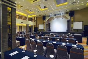 a conference room with tables and chairs and a screen at Aria Barito Hotel in Banjarmasin +113 photos