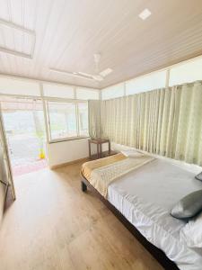 une chambre avec un lit et une grande fenêtre dans l'établissement Greenwoods Budget Villa, à Munnar 15 autres photos