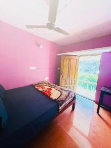 une chambre avec un lit aux murs violets et une fenêtre dans l'établissement Greenwoods Budget Villa, à Munnar