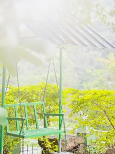 une balançoire verte suspendue à un toit blanc dans l'établissement Greenwoods Budget Villa, à Munnar