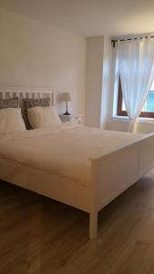 a large white bed in a bedroom with a window at Apartment 179 in Tábor