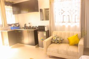 BungomaMiranda suites的客厅里有一张沙发和一个厨房 更多2张照片