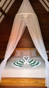 a bed with two crossed hearts on it at Castaway Island Hostel in Nusa Lembongan +46 photos