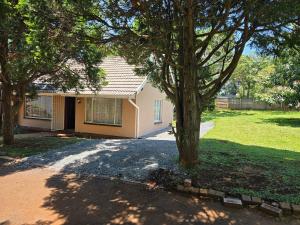 a house with a tree in front of it at Hillcrest Cosy Cottage in Hillcrest