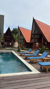 a resort with a swimming pool and lounge chairs at Castaway Island Hostel in Nusa Lembongan +42 photos