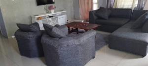 a living room with two chairs and a table at Gravity Apartments & Lodges in Mazabuka