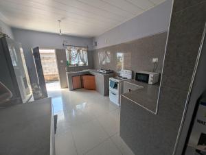 a kitchen with a stove and a microwave at Gravity Apartments & Lodges in Mazabuka