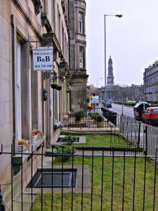 um sinal numa vedação em frente a um edifício em McCrae's Bed and Breakfast em Edimburgo