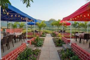 a restaurant with tables and chairs and flowers at Araku Mountview Camping Resort in Araku